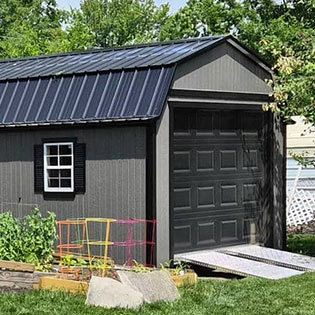 Dark gray garage shed with a black roll-up door and ramp 